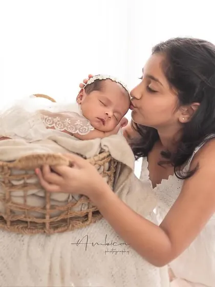 A sweet kiss for the new baby. This image captures the affection and curiosity of an older sibling meeting the newest member of the family for the first time.