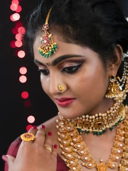 A side profile shot that beautifully captures the contour, highlight, and the intricate details of the eye makeup. The bokeh background makes the bride stand out.