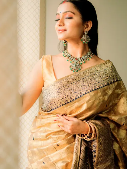 A soft and dreamy bridal inspiration look. The model wears a golden saree, and the makeup is minimal and glowing, with a focus on radiant skin.