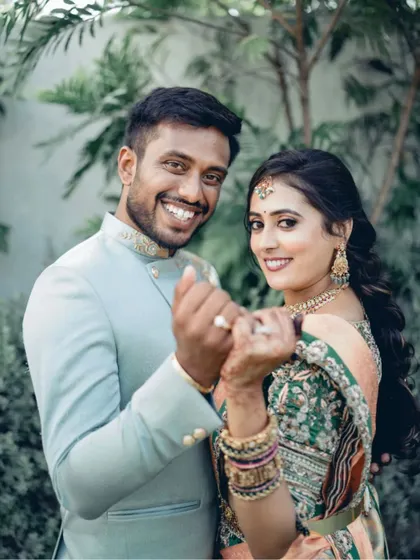 A fun and happy portrait of the newly engaged couple. Their bright smiles and playful pose, showing off their rings, are infectious.