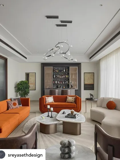A bold and balanced bar and sitting area. The pop of color from the orange sofas energizes the space, while our custom-designed furniture provides a foundation of quality and comfort.