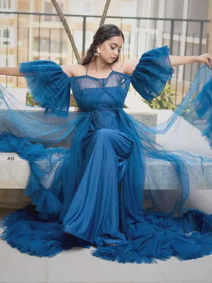 A dramatic and dreamy blue gown with voluminous tulle sleeves and a long train. This is a high-fashion piece perfect for photoshoots or making a bold entrance.