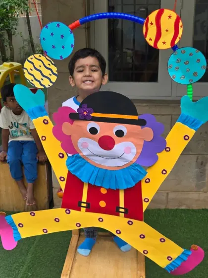A proud smile from a camper with the giant clown he helped create. Group projects help foster a sense of teamwork and shared accomplishment.