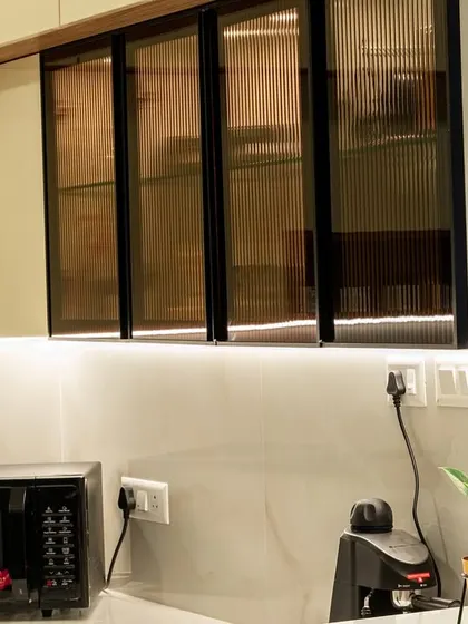 A close-up of fluted glass cabinet doors in a modern kitchen. This detail adds texture and sophistication while partially obscuring the contents for a cleaner look.