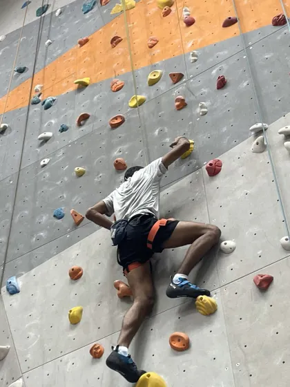 A climber navigates a complex route, demonstrating the strength and technique gained through consistent practice.