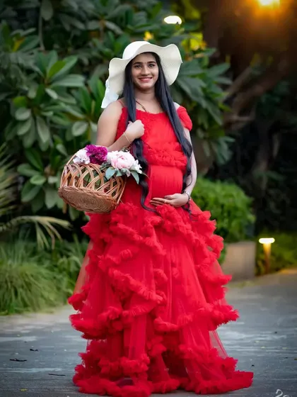 A lovely shot of a client in my red ruffle maternity gown. The outfit is perfect for creating a sweet, pastoral look with props like a hat and a flower basket.