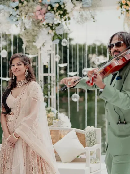 A unique and memorable entrance for the couple at their sundowner engagement. A violinist leads them in, adding a touch of live music and performance art to their special moment.