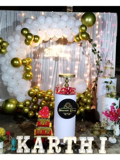 A romantic terrace decoration with a white and gold balloon arch and marquee letters.