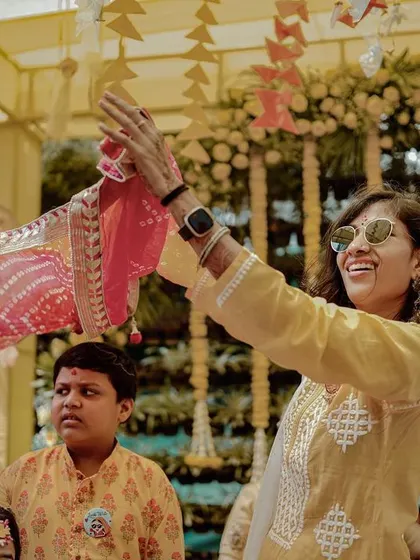 A guest enjoying the Haldi festivities, waving a colorful scarf in the air.