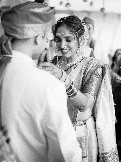 A beautiful black and white shot of the bride placing the mangalsutra on the groom.