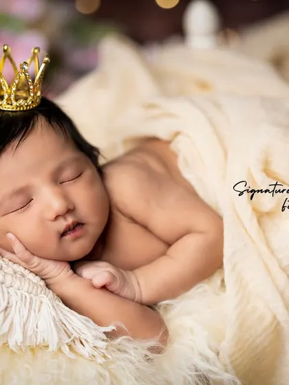 A close-up of a sleeping newborn princess, her tiny crown adding a touch of royalty.