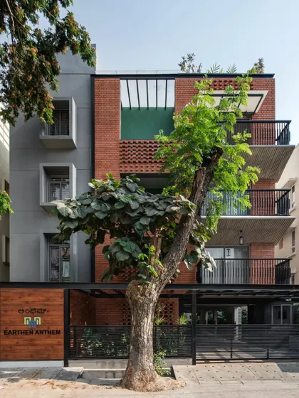 The facade of the Earthen Anthem apartment building, where I used exposed brick and textured concrete. The design works around two beautiful existing trees, making them the stars of the show.