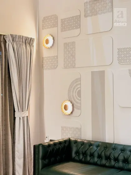 A close-up of the custom wall paneling and the deep green tufted leather of the Chesterfield sofa. The warm glow from the wall sconce accentuates the texture and craftsmanship.