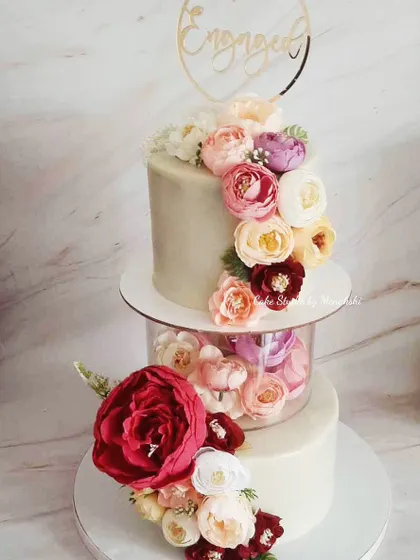 My signature floating tier design makes a stunning centerpiece for an engagement party. This cake is decorated with a cascade of beautiful, colourful flowers for a truly romantic and magical effect.