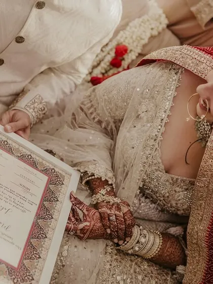 The bride and groom look at each other as they sign their Nikah contract, a moment of shared commitment.