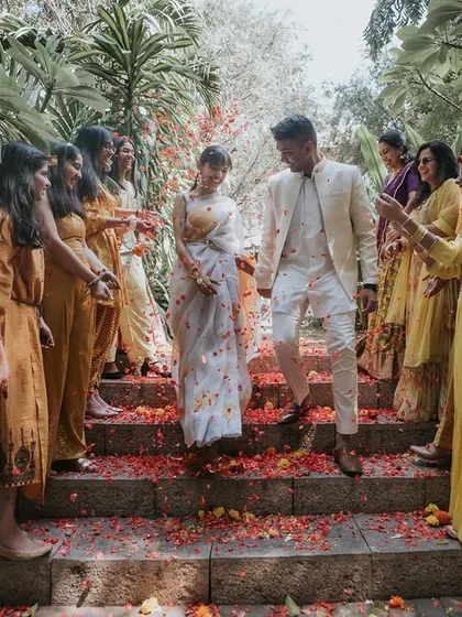 The couple makes their entrance down a staircase showered with flower petals, a simple yet beautiful moment we helped orchestrate.