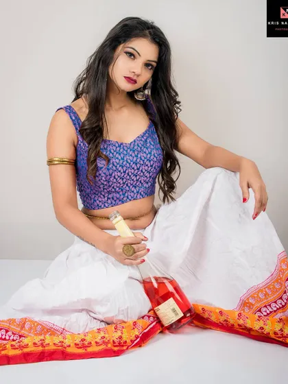 A direct portrait from the 'Nasha' series. The model sits holding the wine bottle, looking at the camera with a compelling gaze that mixes defiance with vulnerability.