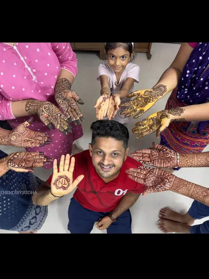 Mehendi is for the whole family. Here's a fun shot with the groom showing his simple initial mehendi, surrounded by the beautifully decorated hands of his family members.