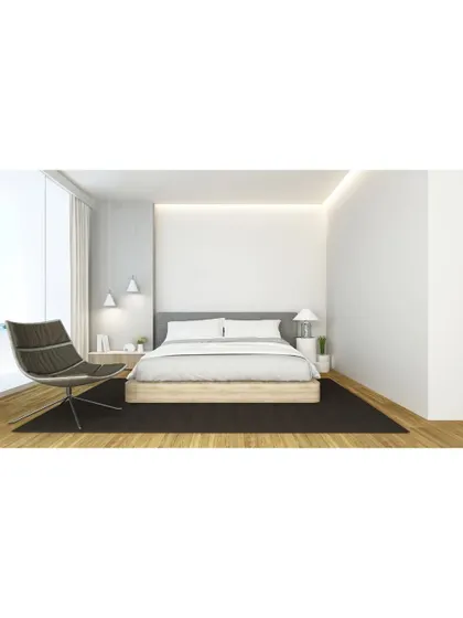 A minimalist bedroom design that focuses on clean lines and a clutter-free environment. The low-profile bed, simple side table, and modern armchair create a space that is calm and conducive to rest.