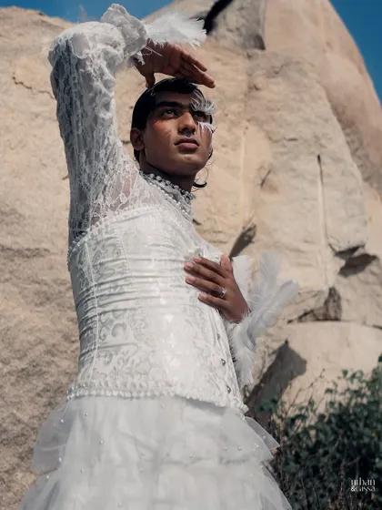 The pose with the hand raised to the sky adds a dramatic, almost theatrical flair to the overall look.