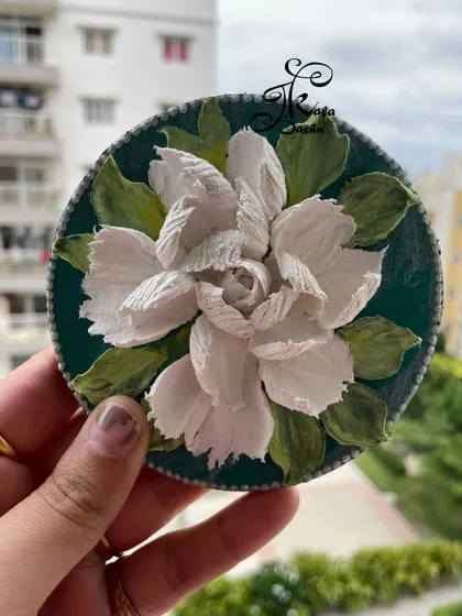 Holding the 6-inch white floral magnet to show its scale.