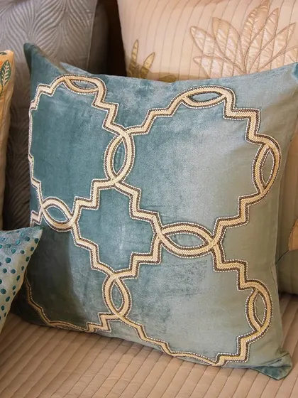 This teal cushion, with its geometric pattern, is perfect for adding a light and airy touch to your summer decor. It pairs beautifully with other textures and patterns for a layered look.
