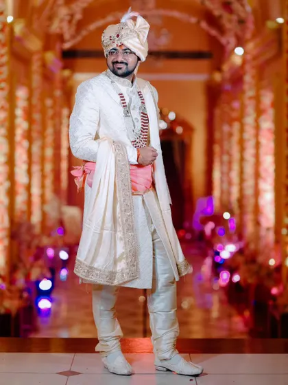 A solo portrait of the groom looking dapper in his ivory sherwani, ready for the big day.