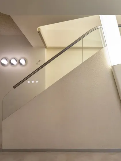 A detail of the staircase, showing the clean geometry and the subtle glow from the integrated lights.