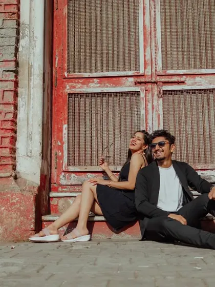 A fun, candid moment of laughter against a rustic red brick wall. These shots showcase your playful side and add a touch of casual, urban cool to your pre-wedding album.