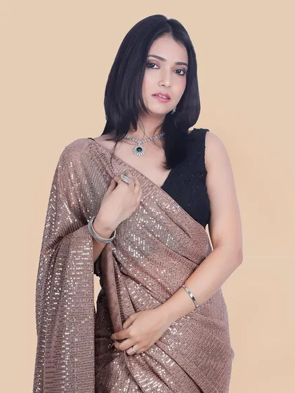 This shot captures the graceful drape of the saree and the model's direct gaze, creating a powerful and elegant image for a fashion catalog.