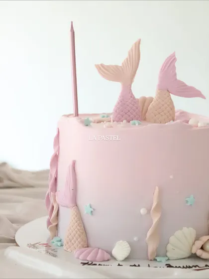 A close-up shot of the pastel mermaid cake, showing the subtle color gradient and the tiny, shimmering details.