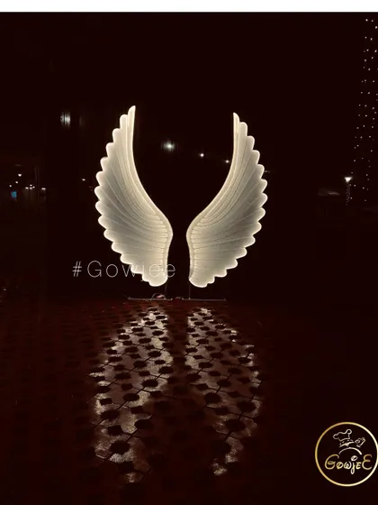 A dramatic shot of illuminated angel wings, a popular and beautiful photo prop for modern events.