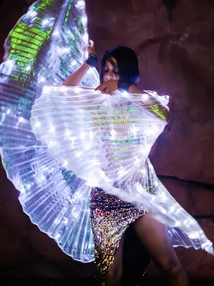 A close-up of the LED wings at Magique. The detail in the costume and the vibrant lights make for a captivating performance, even in an intimate setting.