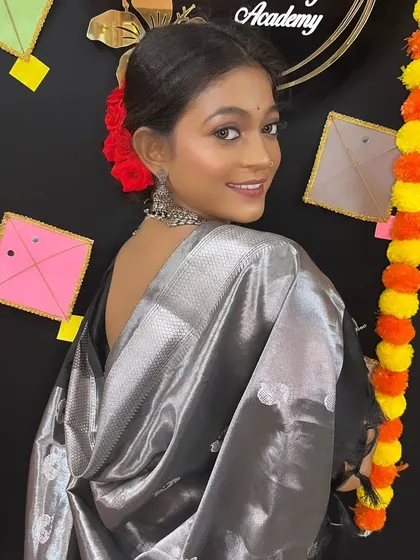 A back view of the model, showcasing the elegant drape of the black saree and her confident pose.