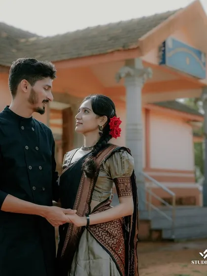 A classic portrait of a couple at a heritage site. Their traditional attire and the simple, elegant backdrop create a timeless and graceful image.