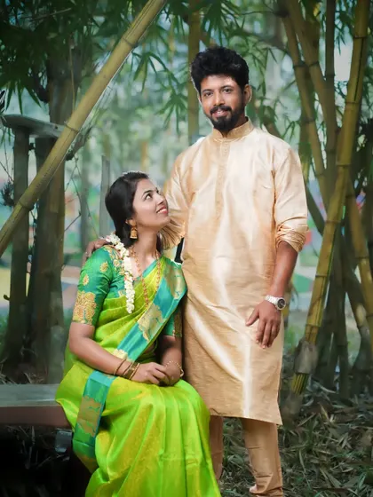 A classic pre-wedding portrait of a couple in traditional attire, set against a bamboo grove. The natural framing and soft light create a serene and timeless photograph.