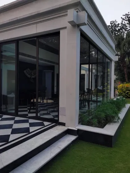 This winter dining area is designed as a glass pavilion amidst the lawn. The classic checkered flooring and full-height glazing offer panoramic views of the garden, creating an exceptional dining experience.