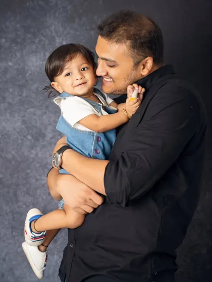 A father holds his child close, sharing a sweet, candid moment. These are the simple, heartfelt interactions that make for the most memorable family photographs.