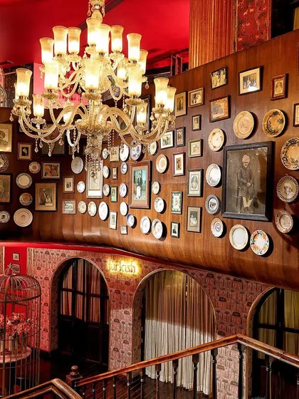 Every detail in my establishment is designed to transport you. This is a view of our grand interiors, where opulent chandeliers and a wall of curated art create a backdrop of timeless, royal luxury for your night.