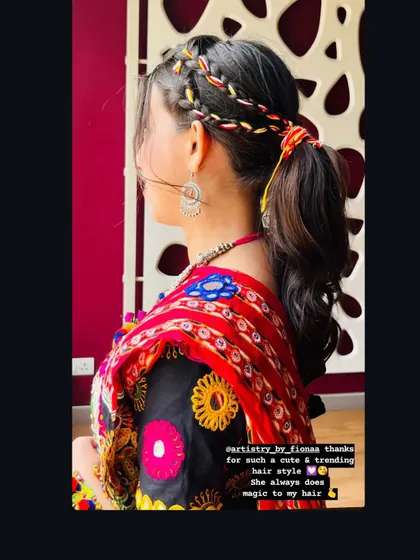 A fun, braided ponytail with colorful threads woven in. This is a great hairstyle for a festive event like Navratri.