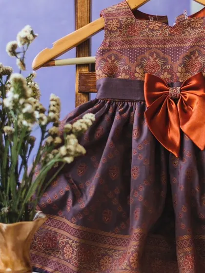 A closer look at the intricate brocade fabric and the lovely burnt orange bow on this unique fusion dress.