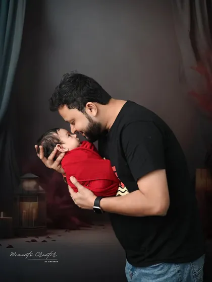 A father's gentle love for his newborn. This intimate photo captures a quiet moment of connection between dad and baby, highlighted by the soft, warm lighting.
