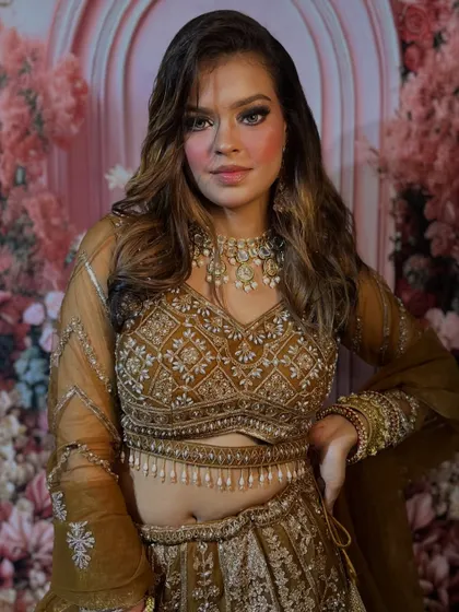 A full-length view of this stunning party outfit. The makeup is designed to complement the heavy embroidery and rich color of the lehenga.
