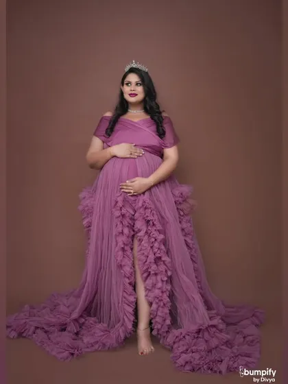 A regal portrait of a mom-to-be wearing a crown and a magnificent purple ruffled gown. Every expecting mother deserves to feel like a queen for a day.