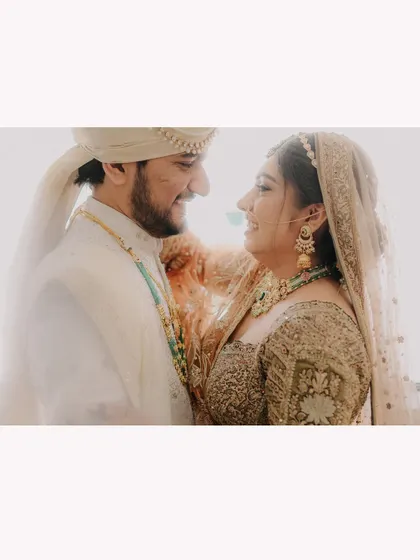 A bright and airy wide shot of the couple sharing a happy, candid moment, creating a light and romantic feel.