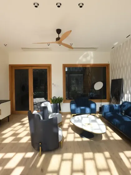 Sunlight filters through the intricate design of the front elevation screens in the Screen House, casting dynamic patterns on the living room floor and walls. As the day unfolds, these shifting shadows animate the space.