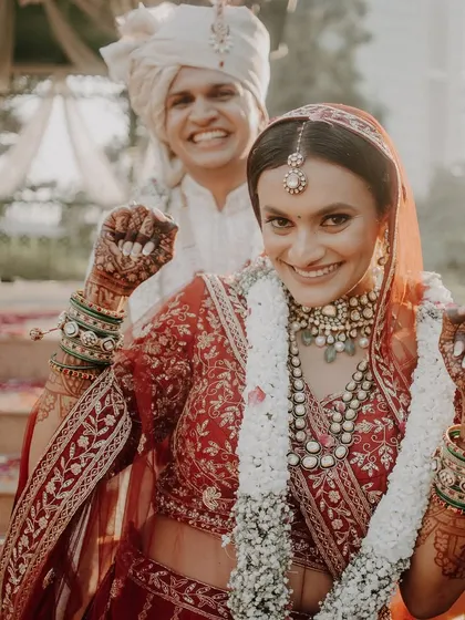 Pure happiness and energy. This bride is ready for her Pheras, rocking a classic red lehenga with a makeup look that's fresh, radiant, and full of life.