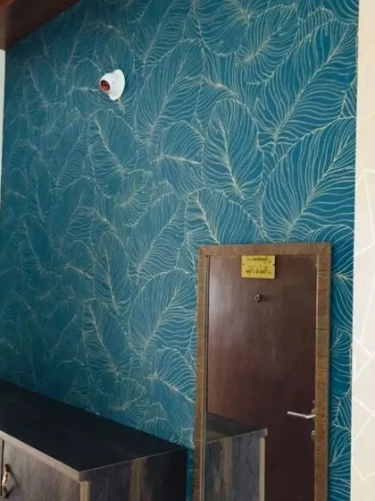 Another view of the popular teal feather wallpaper, showing how it can elevate a simple entryway console table.