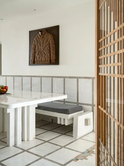 A detail of the dining area, showing the custom bench and the view through a Japanese-style wooden screen.