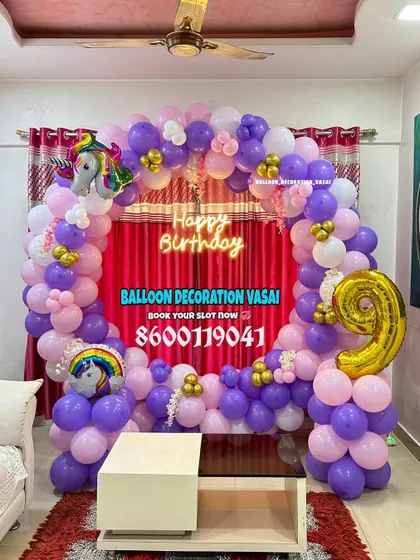 A unicorn-themed balloon arch for a 9th birthday. The vibrant purple and pink balloons are accented with unicorn foil balloons.